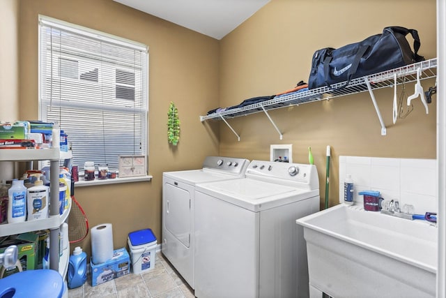 washroom featuring laundry area, independent washer and dryer, and a sink