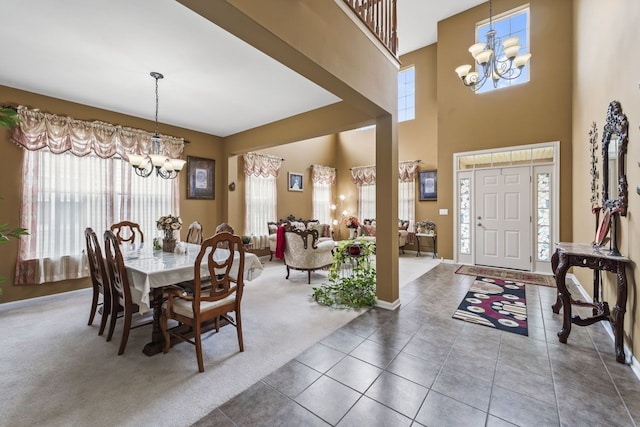 carpeted dining area featuring tile patterned floors, a high ceiling, baseboards, and a chandelier