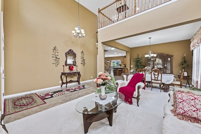 living room with a chandelier, baseboards, a towering ceiling, and carpet floors