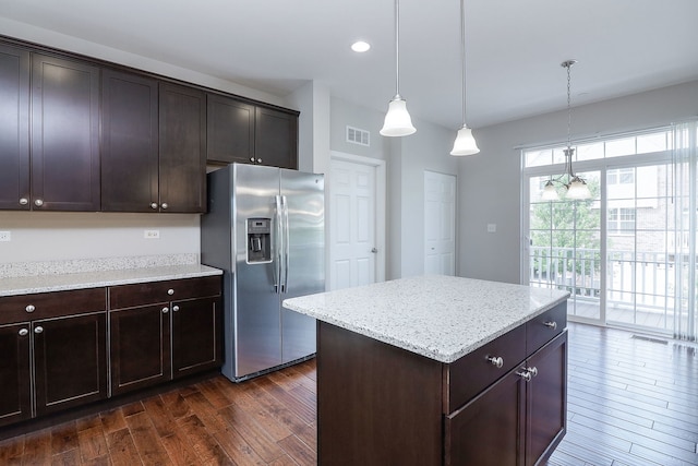 kitchen featuring dark wood-style floors, light stone countertops, dark brown cabinetry, stainless steel refrigerator with ice dispenser, and decorative light fixtures