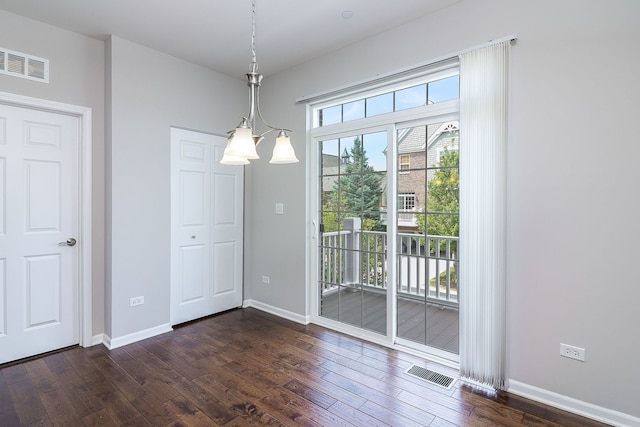 unfurnished dining area featuring visible vents, baseboards, and dark wood finished floors