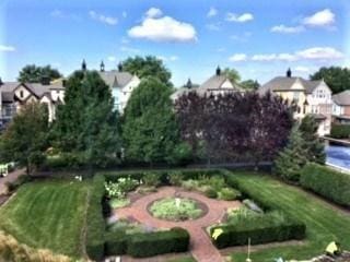 view of property's community featuring a lawn and a garden