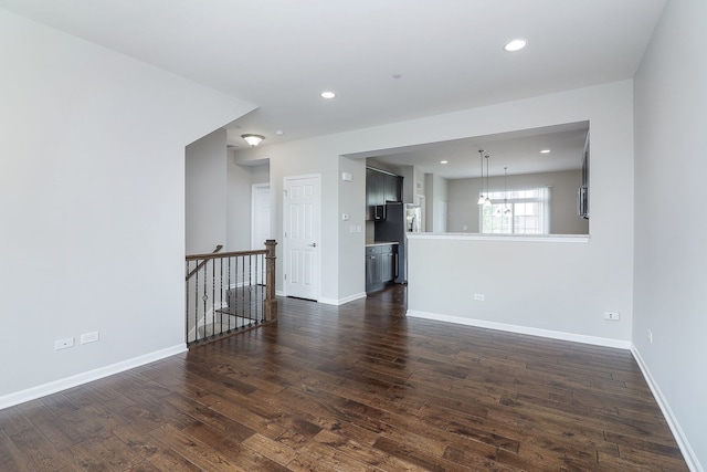 empty room featuring recessed lighting, baseboards, and dark wood-style floors