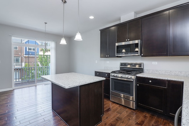 kitchen featuring a center island, light stone countertops, decorative light fixtures, dark wood-style floors, and stainless steel appliances