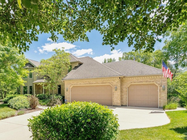 view of front of home featuring brick siding, concrete driveway, an attached garage, and a shingled roof