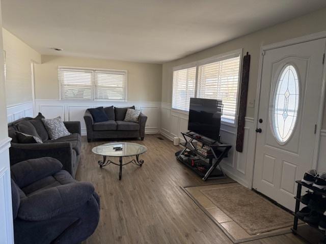 living area with wood finished floors and wainscoting