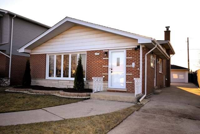 view of front facade featuring brick siding, a chimney, and an outdoor structure