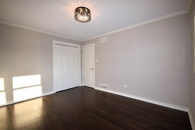 unfurnished bedroom featuring a notable chandelier, visible vents, ornamental molding, and dark wood-style flooring