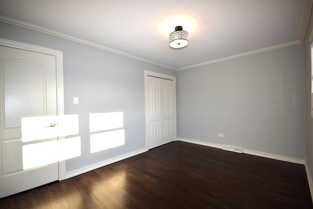 unfurnished bedroom featuring visible vents, a closet, crown molding, baseboards, and dark wood-style flooring