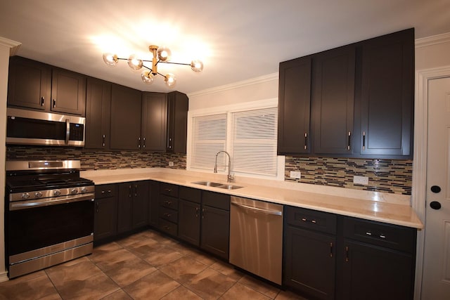 kitchen featuring a sink, a notable chandelier, appliances with stainless steel finishes, and crown molding