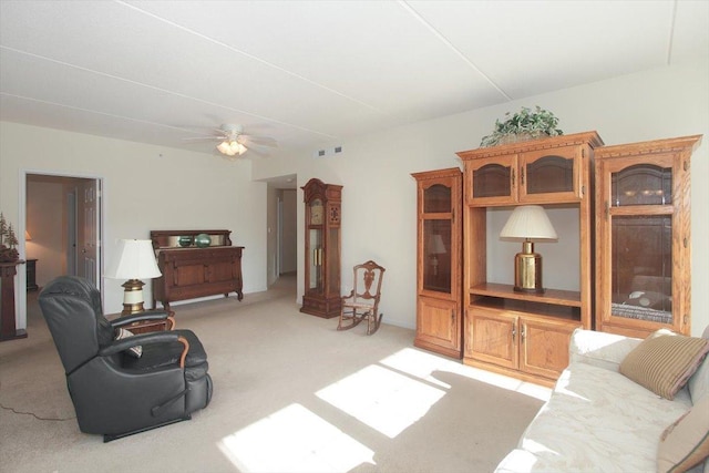 living area featuring visible vents, light carpet, and ceiling fan