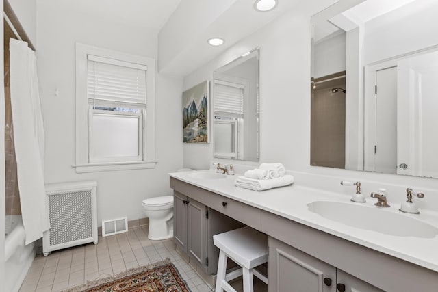 bathroom featuring a sink, visible vents, toilet, and radiator heating unit