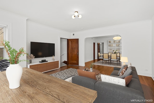 living area with ornamental molding, baseboards, and wood finished floors