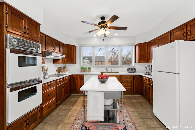 kitchen featuring white appliances, ceiling fan, a sink, light countertops, and under cabinet range hood