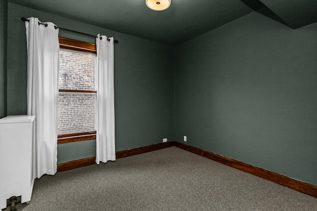 carpeted empty room featuring baseboards