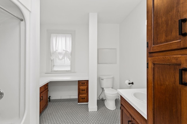 bathroom featuring vanity, toilet, and baseboards