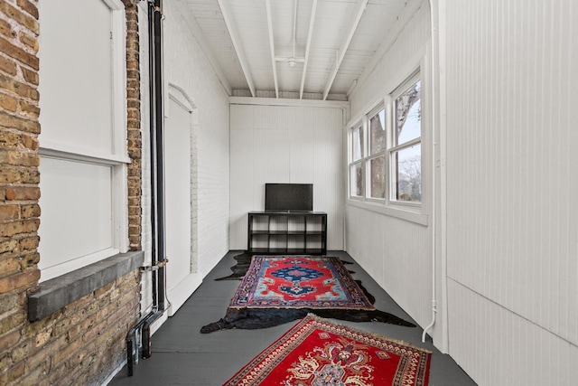 hallway featuring brick wall