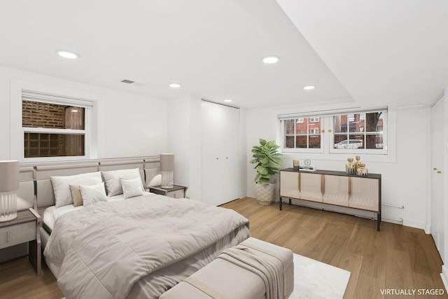 bedroom featuring a closet, recessed lighting, visible vents, and light wood finished floors