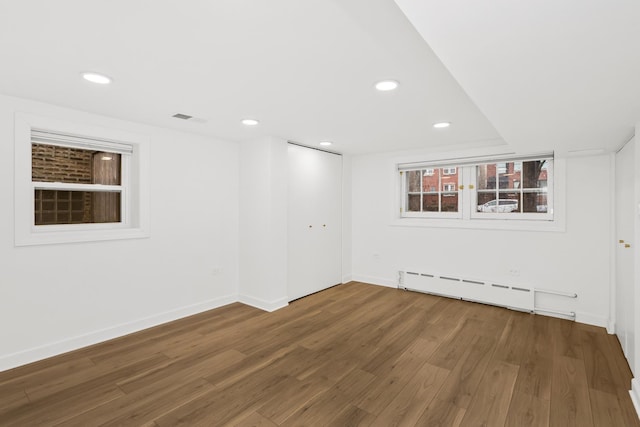 empty room featuring visible vents, recessed lighting, baseboards, and wood finished floors