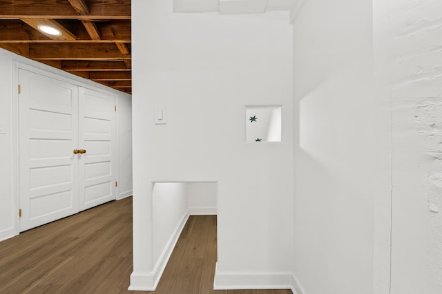 laundry area featuring wood finished floors and baseboards