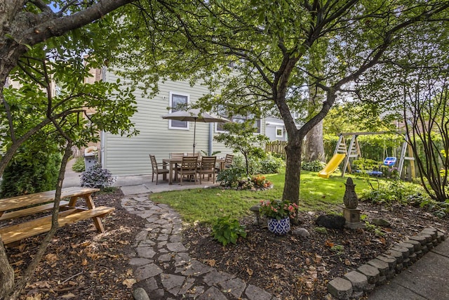 view of yard with a playground, a patio, and fence