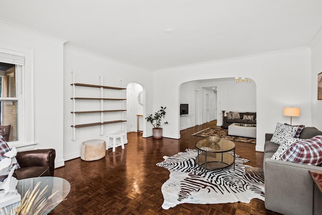 living area with baseboards, arched walkways, and ornamental molding