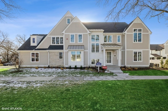 view of front of home with a shingled roof and a front lawn