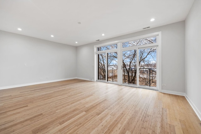 empty room with recessed lighting, visible vents, light wood-style flooring, and baseboards