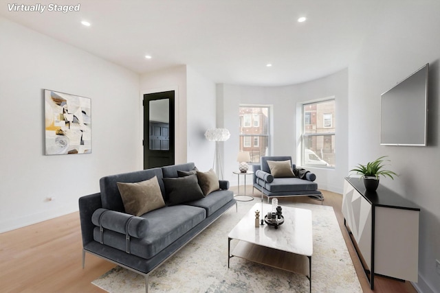 living room featuring recessed lighting, baseboards, and wood finished floors