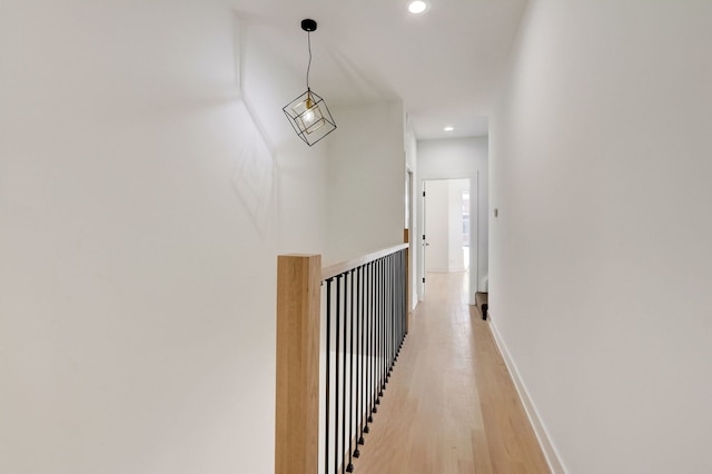 corridor featuring recessed lighting, baseboards, and light wood finished floors