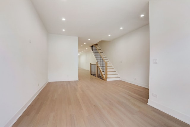 spare room featuring stairs, recessed lighting, baseboards, and light wood finished floors