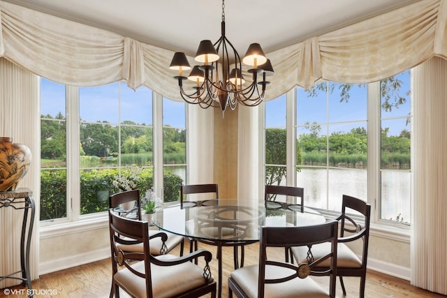 dining area with light wood-type flooring, a wealth of natural light, and a chandelier