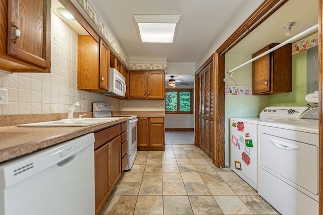 kitchen with white appliances, washing machine and clothes dryer, ceiling fan, decorative backsplash, and brown cabinets