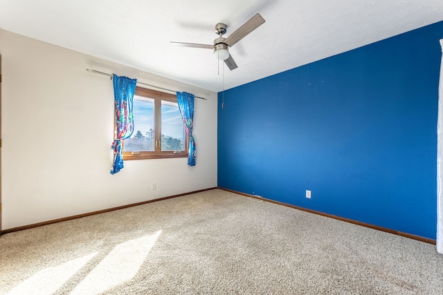 carpeted spare room with baseboards and ceiling fan