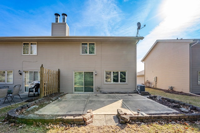 rear view of property with central air condition unit, a patio, and a chimney