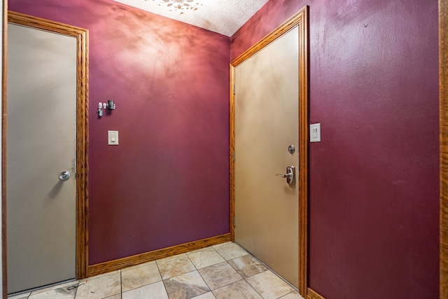 entrance foyer featuring light tile patterned floors and baseboards