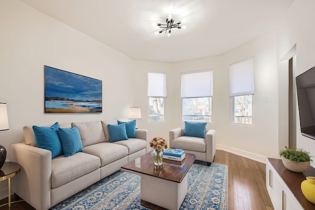 living area with baseboards and wood finished floors