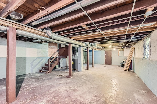 unfinished basement featuring heating unit, stairway, and electric panel