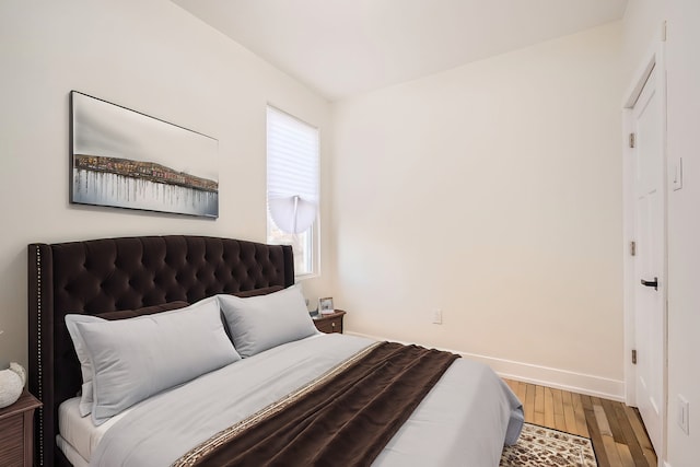 bedroom featuring baseboards and wood finished floors