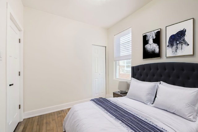 bedroom with a closet, baseboards, and hardwood / wood-style flooring