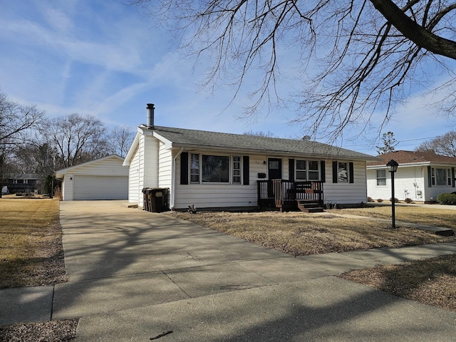 view of front facade featuring a garage, an outdoor structure, and a shingled roof