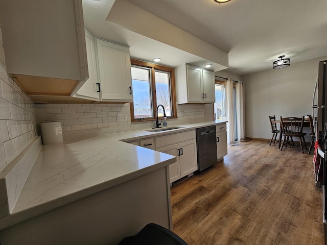 kitchen featuring dark wood finished floors, a sink, decorative backsplash, white cabinets, and dishwasher