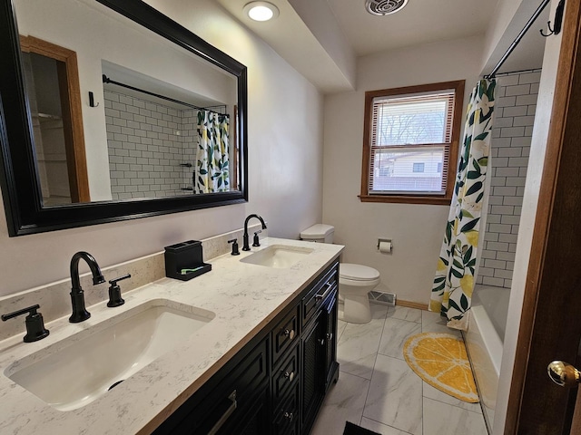 full bathroom with double vanity, marble finish floor, toilet, and a sink