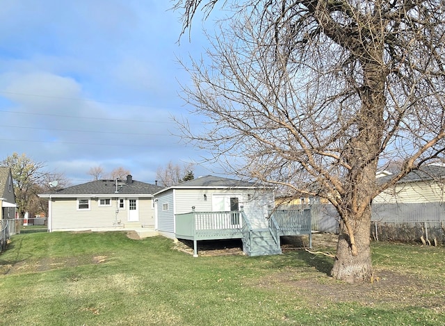 rear view of house with a fenced backyard, a lawn, roof with shingles, and a wooden deck