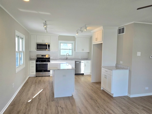 kitchen featuring visible vents, light wood-style flooring, a sink, stainless steel appliances, and white cabinets