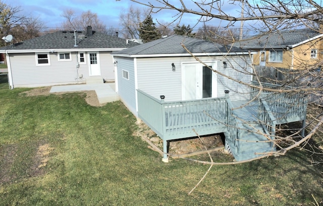 back of property featuring a wooden deck, a yard, and a shingled roof