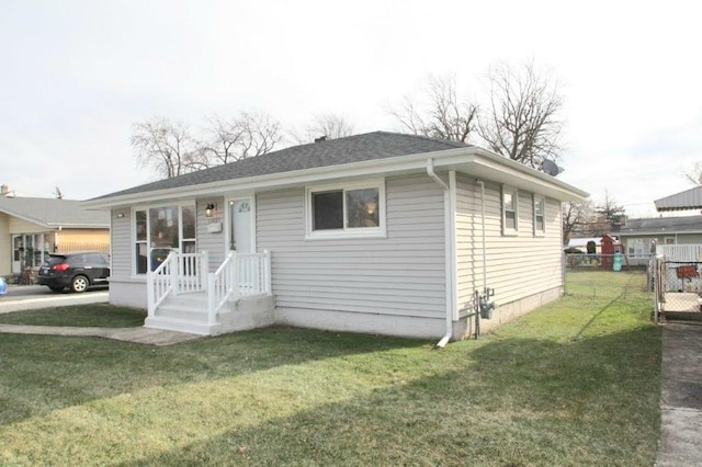 bungalow featuring a front yard, fence, and a shingled roof