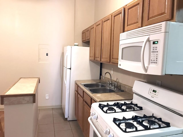 kitchen featuring a sink, white appliances, brown cabinets, and light tile patterned floors