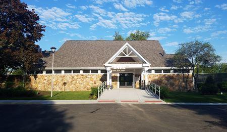 view of front of property featuring stone siding and fence