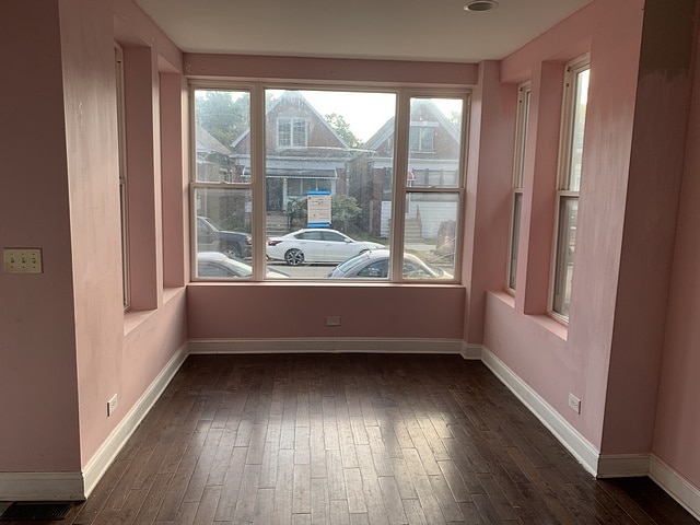 spare room featuring visible vents, baseboards, and dark wood-style flooring